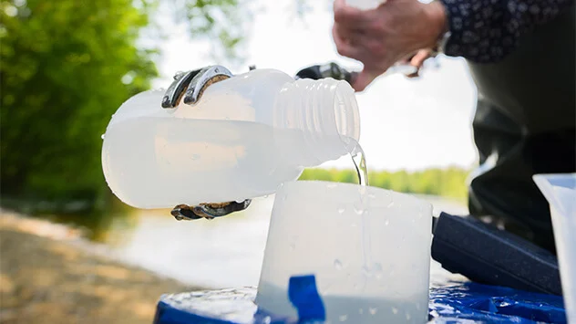 Wasserprobe von einem See wird für das Labor umgefüllt