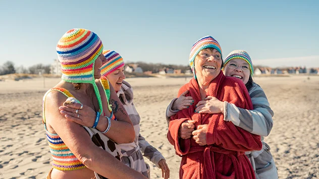Eisbaden in der Ostsee - Bild: TMV/Gross Vier Frauen am Strand in Bademänteln.