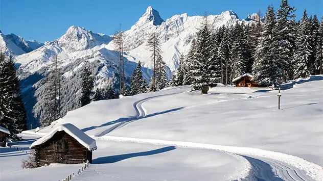 Verschneite Berglandschaft mit uriger Hütte im Montafon