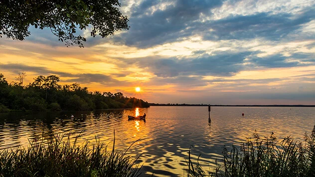 Sonnenuntergang über den Steinhuder Meer mit einem Boot im Vordergrund