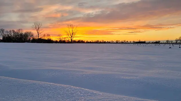 Besonders schön ist das Farbenspiel der Morgendämmerung über schneebedeckten Feldern und Wiesen.