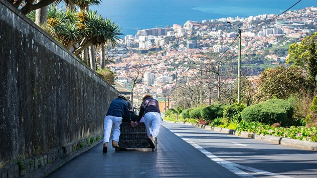 Traditioneller Korbschlitten fährt ins Tal nach Funchal