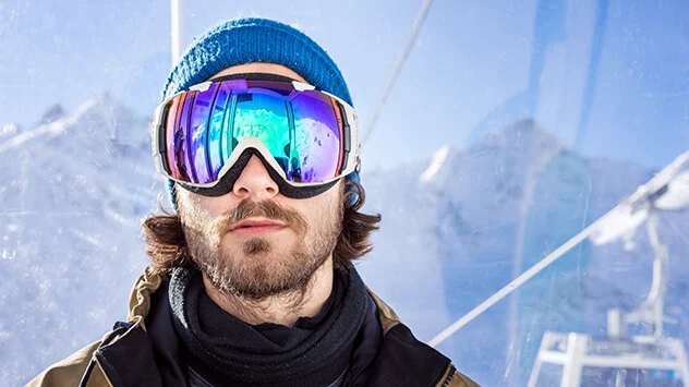 Mann trägt Skibrille mit UV-Schutz in den Bergen
