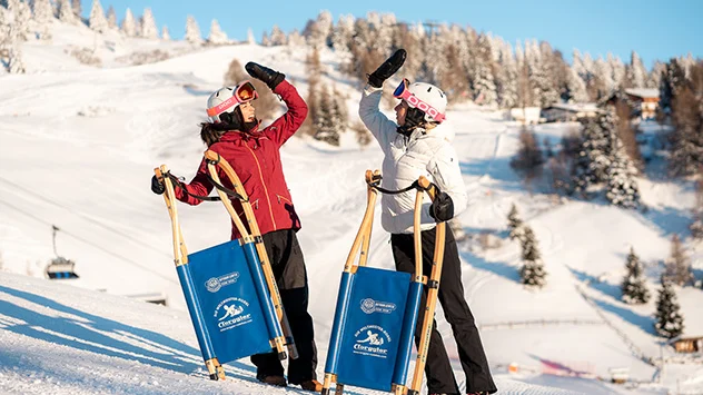 Winterurlaub in Sterzing-Ratschings-Gossensass - Bild: Rosskopf-Sterzing / 99tales Zwei Rodlerinnen mit Schlitten geben sich ein High-Five