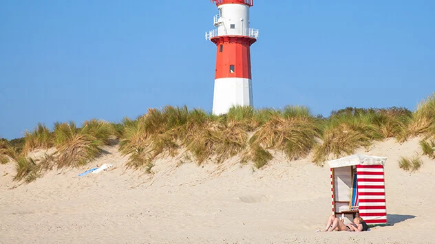 Strand von Borkum mit Strandkorb und Leuchtturm