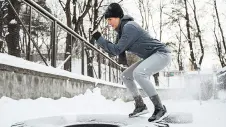 Eine Frau treibt Sport in der winterlichen Landschaft.