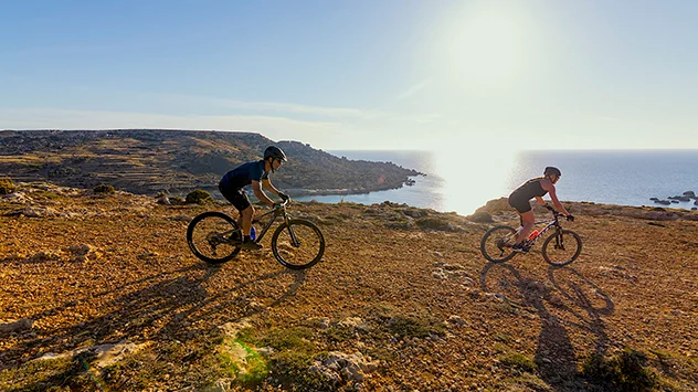 Zwei Fahrradfahrer radeln entlang der Küste