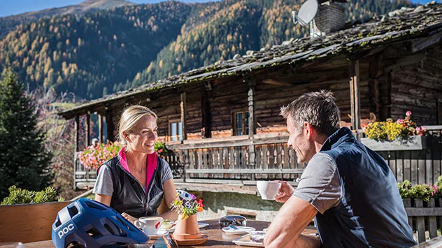 In der Region Gsiesertal-Welsberg-Taisten trifft Tradition auf Genuss - Bild: TG Gsiesertal / Harald Wisthaler Ein Paar genießt die Pause auf einer Almhütte