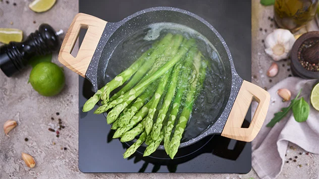 Grüner Spargel wird in einem Topf gekocht