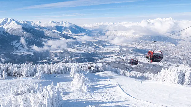 Gondeln über einer Winterlandschaft bei schönstem Wetter