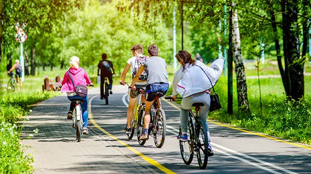 Gruppe von Menschen fährt Rad durch einen Park