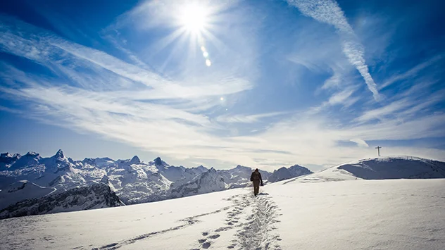 Winterwanderer in einer Landschaft aus Eis und Schnee in den Bergen