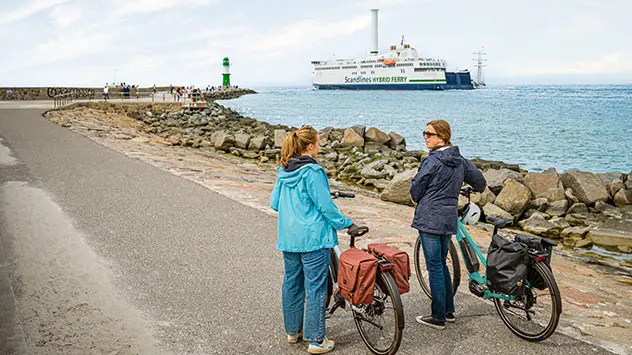 Zwei Frauen mit Fahrrädern blicken auf die Ostsee