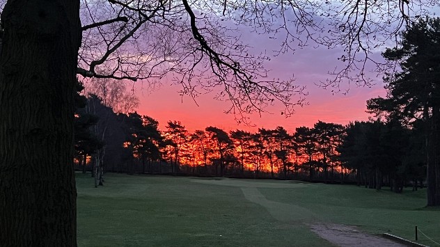 Deep red sunrise over a golf course in Oxford.