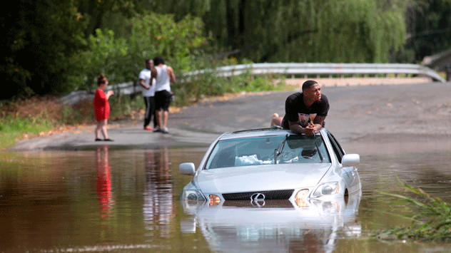 A driver waits to be rescue after getting stuck while attempting to drive through a flooded stretch of road in Collinsville, Missouri.