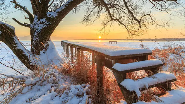 Sonnenuntergang über dem winterlichen Chiemsee