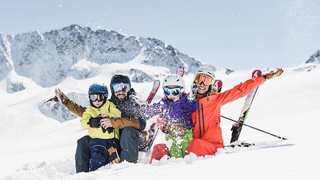 Familie mit Skiern auf der Piste