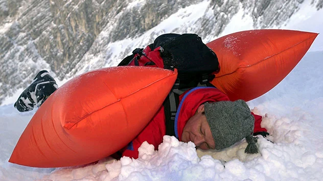 in Lawinenrucksack mit Airbag-System ist eine Sicherheitsausrüstung - Mann auf Schnee liegend