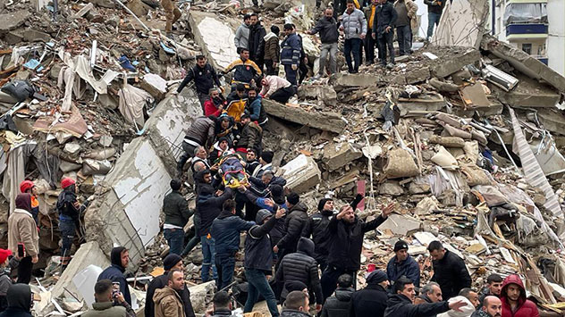 In Adana tragen Rettungskräfte eine Person aus den Trümmern eines Gebäudes.