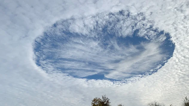 Ein großes Wolkenloch hat sich am Schäfchenhimmel aufgetan. Im Zentrum dieser sogenannten Hole-Punch-Clouds entstehen neue feine Federwolken.