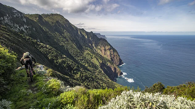 Ein Mountainbiker fährt entlang der Küste Madeiras