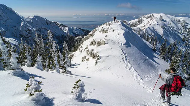 Wanderer in der verschneiten Berglandschaft im Nationalpark