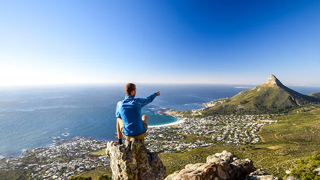 Junger Mann blickt vom Tafelberg über Kapstadt
