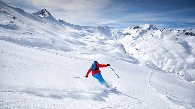 Abfahrer auf steiler Piste im Winter