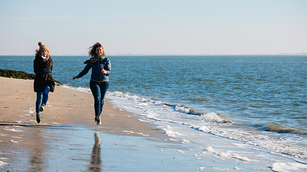 Frauen laufen am Strand von Norderney