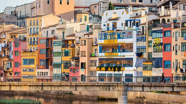 Fahrradfahren in Katalonien - Bild: Tristan Cardew Radfahrer vor der bunten Häuserkulisse in der Stadt Girona