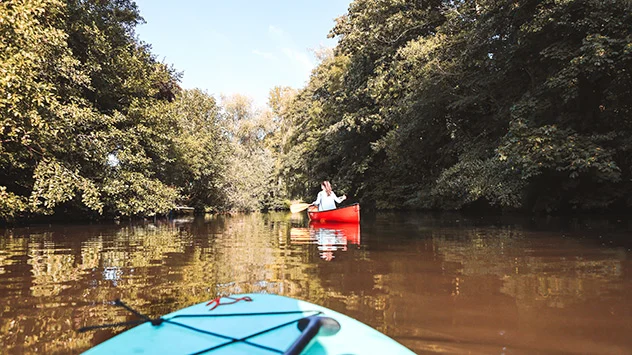 Kanufahrer fahren auf einem Fluss in Niedersachsen