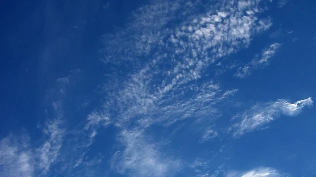 Wenige Schäfchenwolken am stahlblauen Himmel