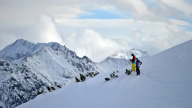 Skifahrer an tiefverschneiten Hang in den Bergen