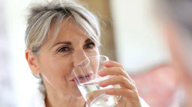 Frau trinkt ein Glas Wasser