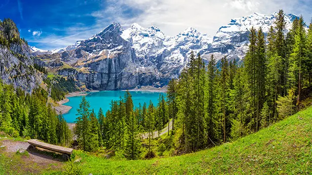 Blick auf den Oeschinensee zwischen verschneiten Bergen in der Schweiz