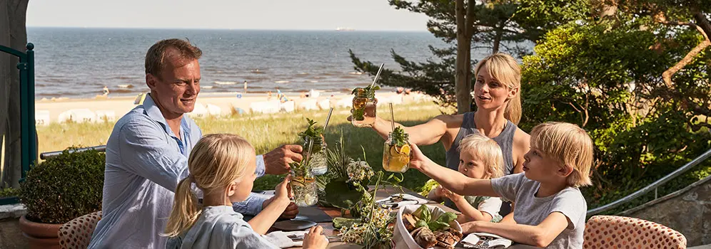 Familie frühstückt mit Blick auf das Meer