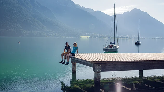 Paar sitzt auf einem Steg im Achensee