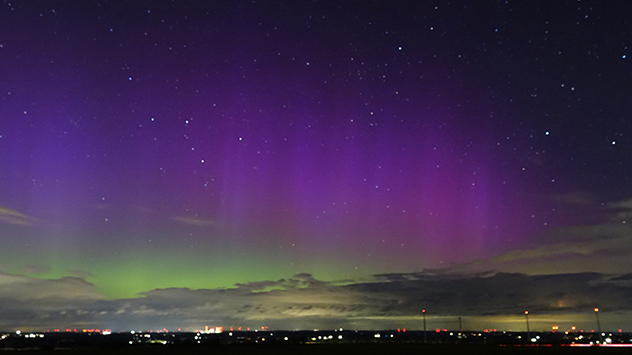 Wie ein seidener Vorhang aus violetten Farbtönen tanzen die Nordlichter über den Himmel.