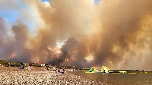 Massive dark clouds of smoke from a forest fire rise into the sky on the Greek island of Rhodes. 