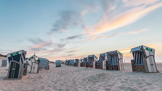 Sonnenuntergang über Strandkörben am Strand von Norderney