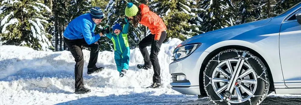 Familie sicher im Schnee mit Schneeketten