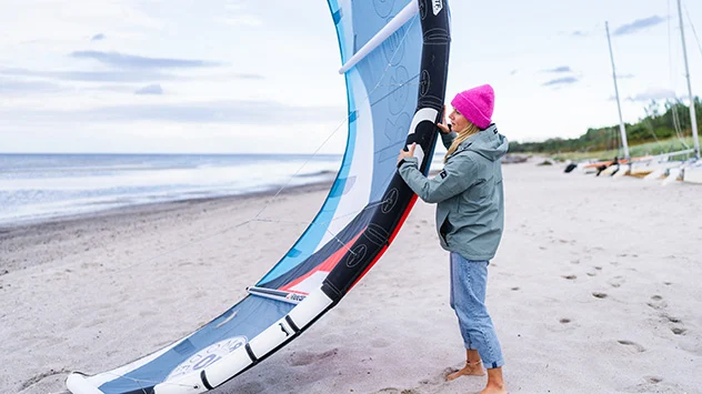 Workation auf der Ostseeinsel Poel - Bild: TMV/Gross Eine Frau bereitet sich aufs Kitsurfen am Timmendorfer Strand vor.