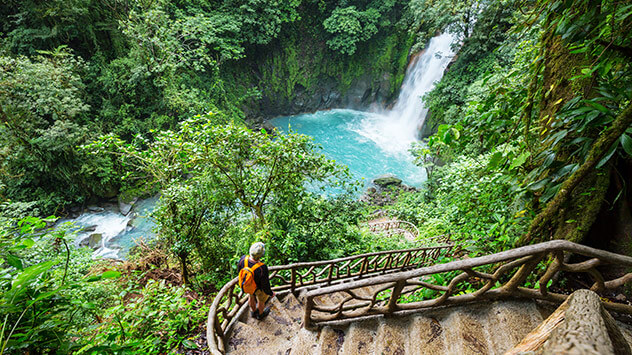 Wanderin beobachtet Wasserfälle im Regenwald