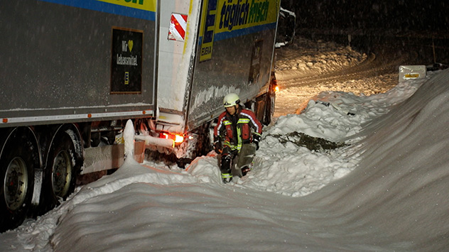 Lastwagen bei Schnee im Straßengraben