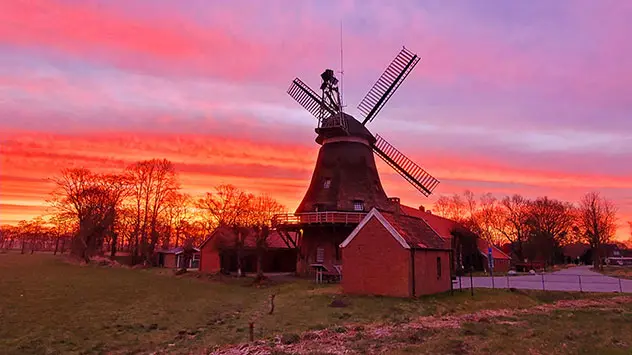 So stimmungsvoll kann der Tag beginnen. Der Morgenhimmel färbt sich über Bagband im Landkreis Aurich in Ostfriesland in intensives Rot.