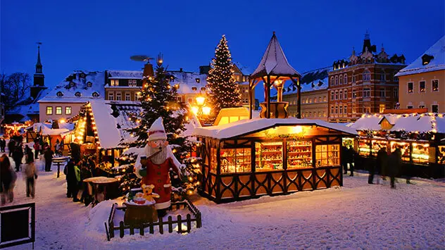 Verschneiter Weihnachtsmarkt in der Dämmerung