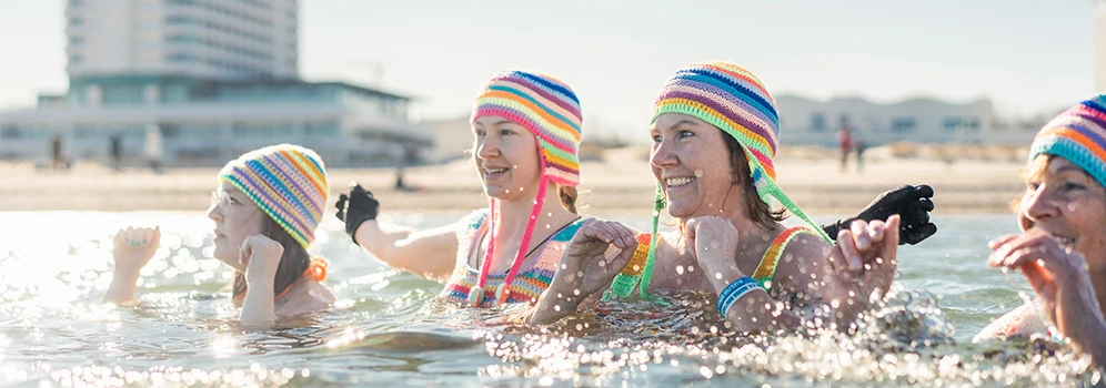 Eisbaden in der Ostsee - © TMV/Gross Frauen mit bunten Häkelmützen baden in der eisigen Ostsee