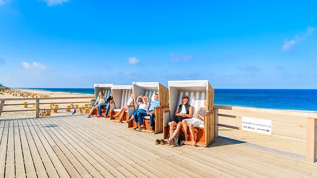 Sonnenbadende in Strandkörben auf der Promenade von Wenningstedt