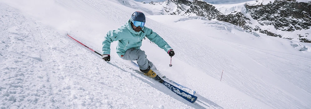 Skifahrer fährt in der Winterdestination Saas-Fee/Saastal eine Piste hinab