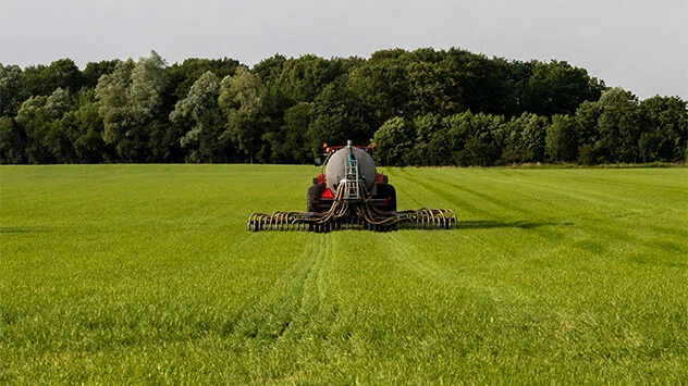 Feld wird von einem Traktor gedüngt